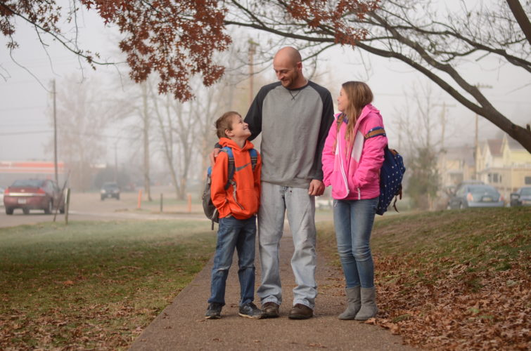 Cory Meeks, 31, of Marietta, walks his two children, Brooke, 11, and Ethan, 8, to Phillips Elementary School recently while sharing smiles and laughs. HANNAH KITTLE The Marietta Times